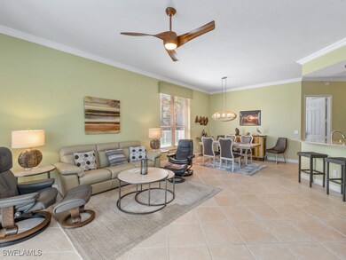 Living room featuring a ceiling fan, light tile pa