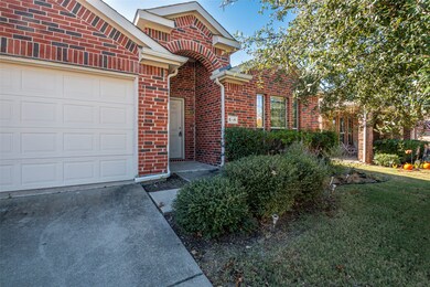 View of front of house with brick siding, a front lawn, concrete driveway, and a garage