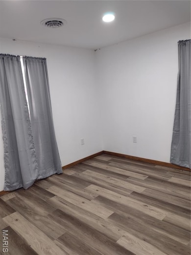 Empty room featuring wood finished floors and recessed lighting