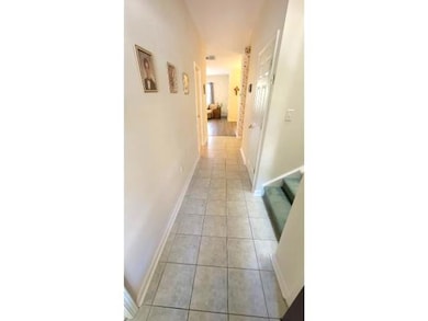 Corridor with light tile patterned floors and base