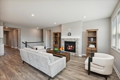 Resting on the center wall of the main level family room, the home's gas fireplace. This is the perfect backdrop for families of any lifestyle. 