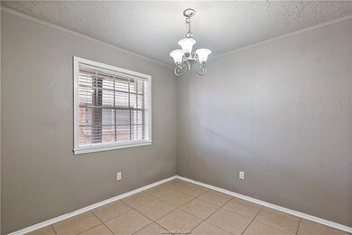 Empty room with a chandelier, a textured ceiling,