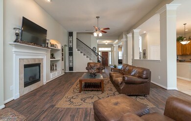 The extended foyer in the home flows seamlessly into the comfortable family room featuring a stylish lighted ceiling fan, high ceiling, recessed lighting, handsome wood-look flooring, and a convenient granite serving bar into the adjacent kitchen.