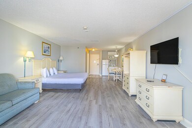 Bedroom featuring freestanding refrigerator, a tex