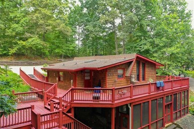 Back of house featuring a deck, stairs, a shingled