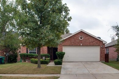 Ranch-style home with a front lawn, concrete driveway, brick siding, and a garage