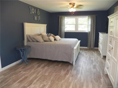 Remodeled master bedroom with wood laminate throug