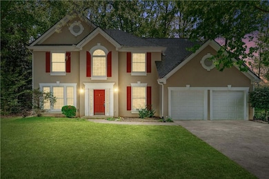 Colonial inspired home featuring driveway, stucco 