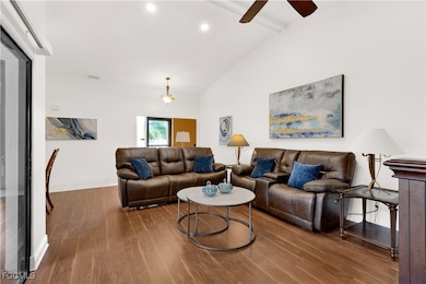 Living room featuring beam ceiling, wood finished floors, a ceiling fan, high vaulted ceiling, and recessed lighting