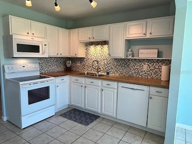 Updated kitchen with butcher block counters and tile backsplash