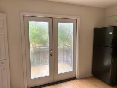 Doorway featuring french doors, light wood-type flooring, and baseboards