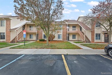 View of building exterior featuring stairway and uncovered parking