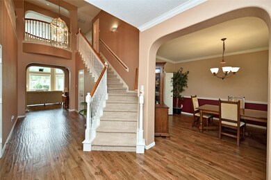 The foyer sets the tone right up front for this home with its two-story ceiling, crown molding and curved staircase. Notice the architectural interest created by the soaring ceilings, opera balcony and archways.
