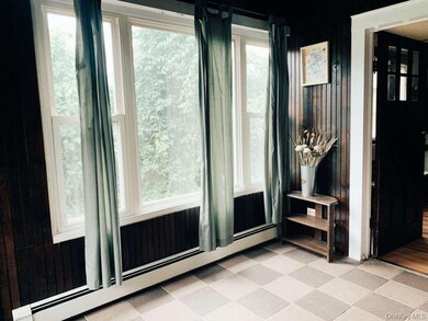 Entryway featuring a baseboard heating unit, wood walls, and tile patterned floors