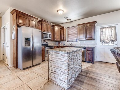 Kitchen featuring light stone counters, light wood