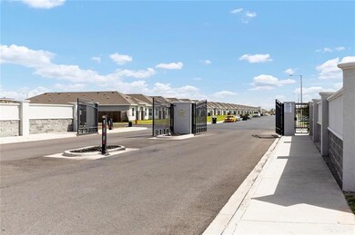 View of asphalt street with a residential view, street lights, curbs, a gated entry, and sidewalks
