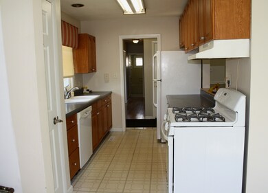 Galley style kitchen with white appliances, refrig