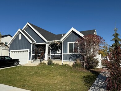 View of front facade featuring a front yard, a porch, a shingled roof, board and batten siding, and an attached garage