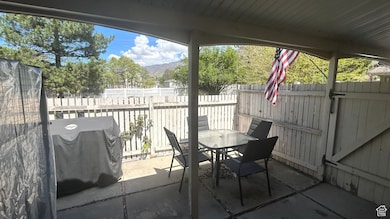View of patio / terrace featuring outdoor dining area, a fenced backyard, a mountain view, and grilling area