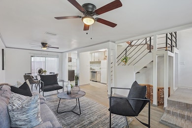 Living room with ceiling fan and light hardwood / 