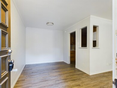 Spare room featuring wood finished floors, crown 