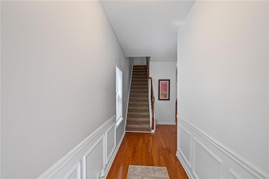 Hallway featuring a decorative wall, light wood-st