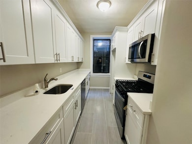 Kitchen with white cabinets, stainless steel appliances, and sink