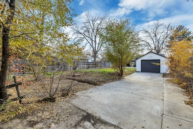View of yard featuring an outdoor structure, driveway, and a garage