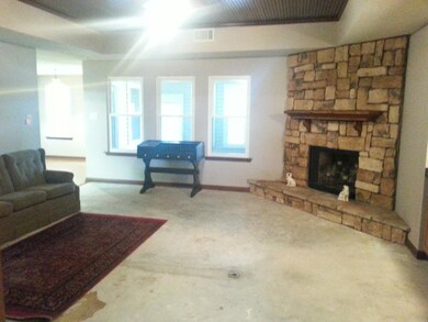 Den view with wood burning fireplace & tongue and