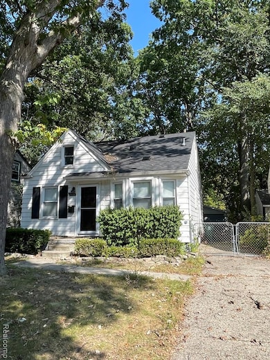 Bungalow with a gate and view of scattered trees