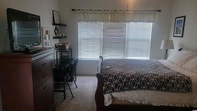 Bedroom featuring light carpet