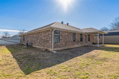 Rear view of house with central AC unit, a lawn, fence, a patio area, and brick siding