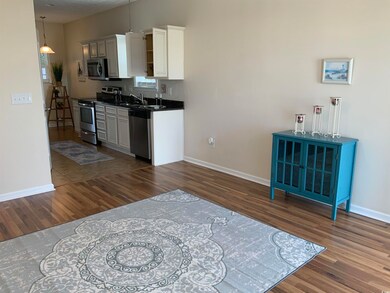 Kitchen with appliances with stainless steel finishes, dark wood-type flooring, baseboards, and grantie counter tops