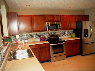Kitchen. Kitchen with Cherry Cabinets, Glass Block Backsplash, & Stainless Steel Appliances