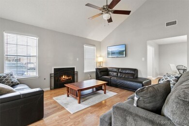 Living area with visible vents, a warm lit firepla