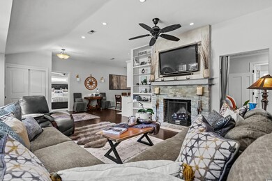 Living area with ceiling fan, wood finished floors, recessed lighting, and a fireplace