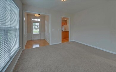 Carpeted spare room featuring a wainscoted wall