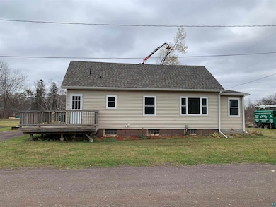 Back of house featuring a wooden deck and a yard