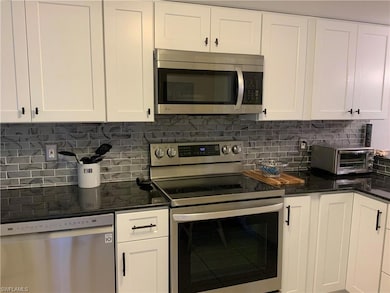 Kitchen with decorative backsplash, appliances wit