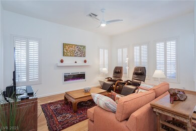 Open concept living room with shutters, ceiling fa