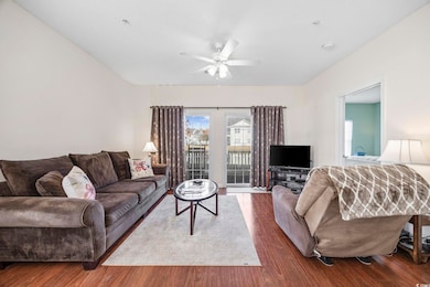 Living room with ceiling fan and dark hardwood / w