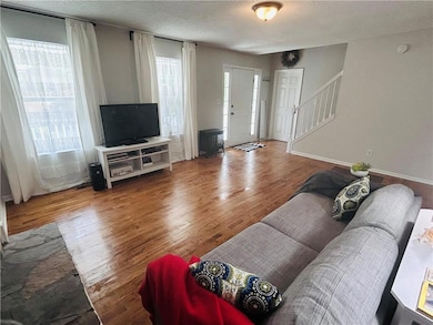 Living room featuring stairs, a textured ceiling, 