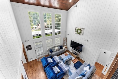 Living area featuring wood finished floors, healthy amount of natural light, wood ceiling, and wood walls