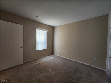 Carpeted spare room featuring baseboards