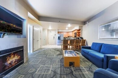 Carpeted living room with a glass covered fireplac