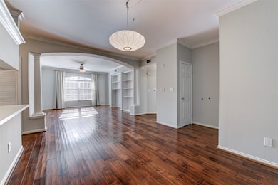 This photo shows an alternate view of the open-concept living area. Room features a ceiling fan with light kit, working in combination with abundant natural light. The area flows seamlessly into a modern kitchen with freshly painted cabinetry and built-in appliances.