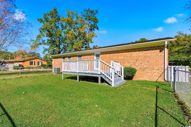 Rear view of property featuring a fenced backyard, brick siding, a deck, a gate, and stairs