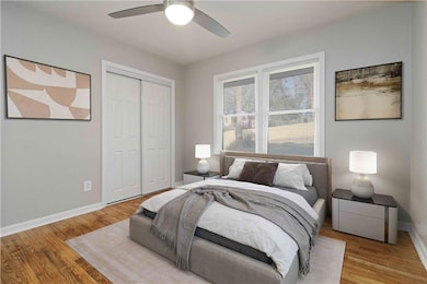 Bedroom with a closet, wood finished floors, and a ceiling fan