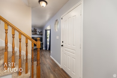 Foyer with stairway and dark wood-style flooring