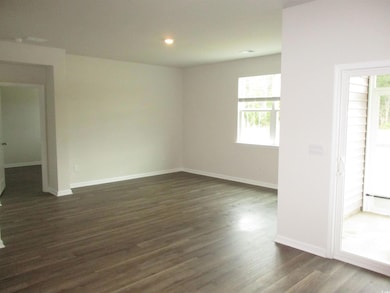 Empty room featuring dark wood-type flooring and recessed lighting
